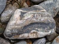 Dunkelgraue Vertiefungen in hellgraubraunem Stein